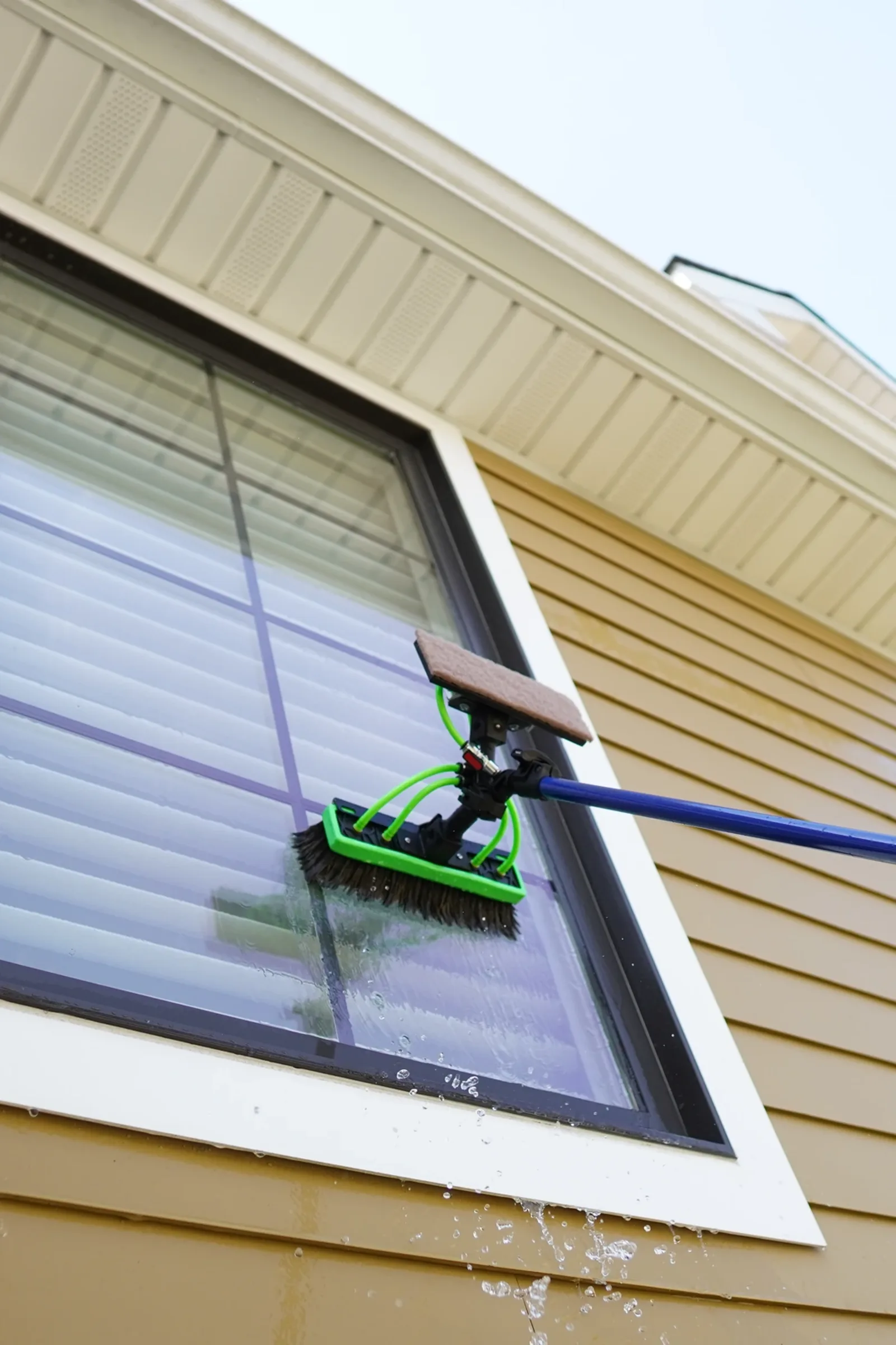Pure-water pole cleaning a second-story window in Westchester County