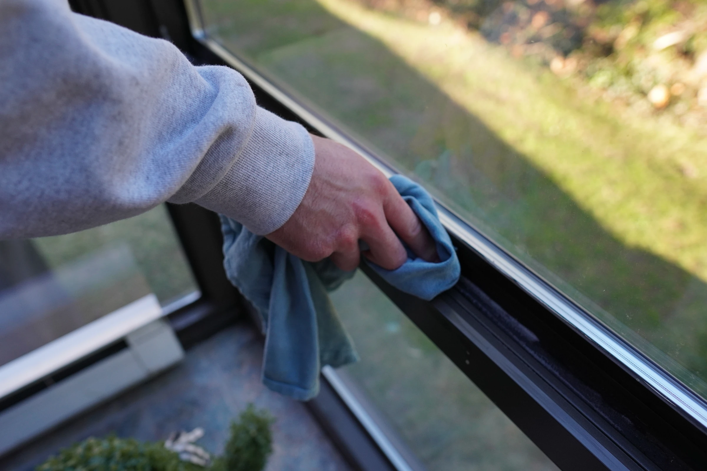 Window track wiped clean by hand along the sill