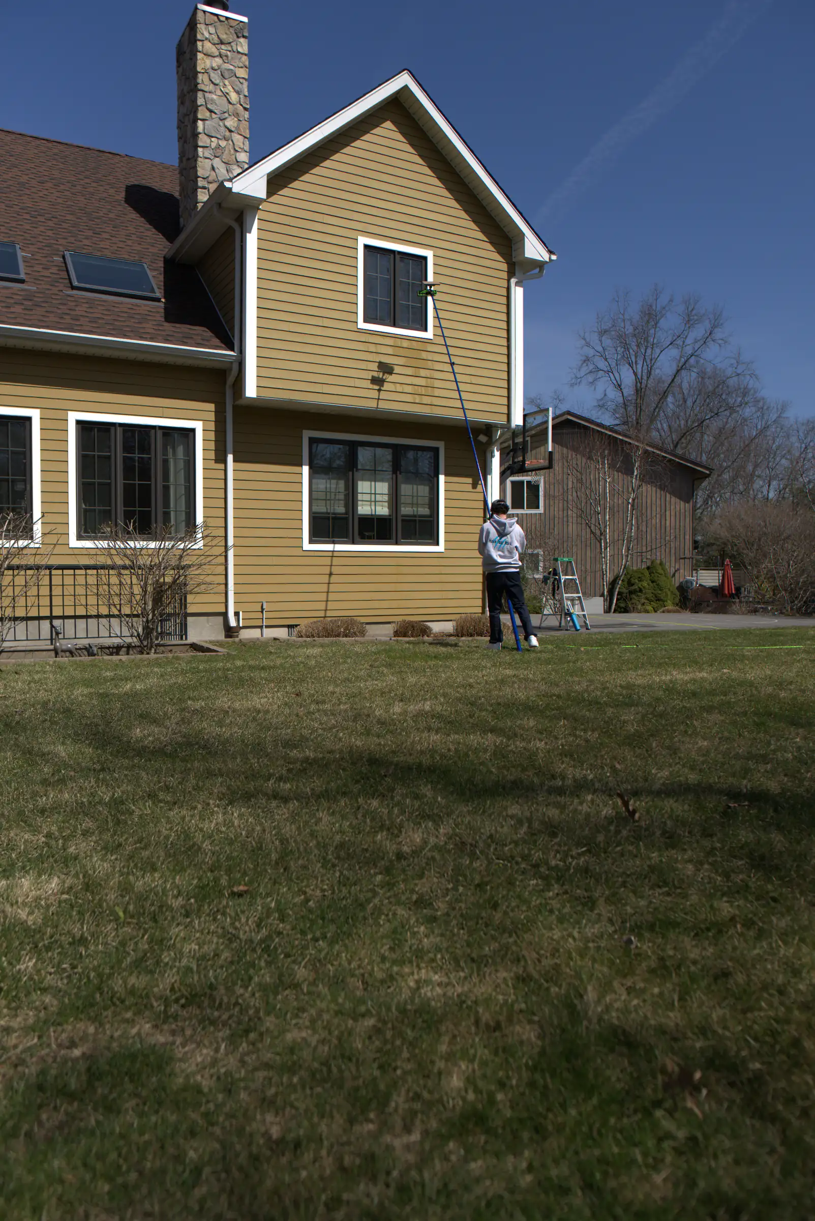 Yellow clapboard colonial after a full exterior window clean